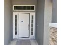 White front door with sidelights and stone accents at 36158 Welsh Glade Rd, Dade City, FL 33525