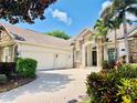 Charming stone accented home with a three-car garage and a brick paver driveway at 1227 Toscano Dr, Trinity, FL 34655