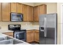 Well-lit kitchen featuring stainless steel appliances and wood cabinets at 5723 Autumn Shire Dr, Zephyrhills, FL 33541