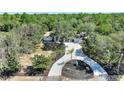 House with circular driveway and fountain in a wooded area at 13231 Snowy Plover Ave, Weeki Wachee, FL 34614