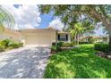 Single-story villa with a two-car garage and a lush green lawn at 2346 Nantucket Dr # 58, Sun City Center, FL 33573