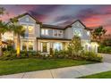 Elegant two-story home with manicured landscaping and a welcoming front entrance at sunset at 7135 Graybrook Dr, Wesley Chapel, FL 33545