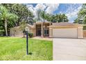 Charming single-story home boasts a well-manicured lawn, mature trees, and an attached two-car garage at 3501 Country Creek Ln, Valrico, FL 33596