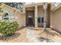Inviting front entrance features a brick pathway, manicured bushes, and a covered porch with grand columns at 3501 Country Creek Ln, Valrico, FL 33596