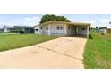 Single-wide manufactured home with carport and well-maintained lawn at 5353 Comanche St, Zephyrhills, FL 33542