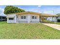 Single-wide manufactured home with carport and well-maintained lawn at 5353 Comanche St, Zephyrhills, FL 33542
