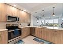 Modern kitchen with light wood cabinets and stainless steel appliances at 415 Island Way # 502, Clearwater Beach, FL 33767