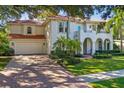 Stunning two-story home with a red tile roof, arched entryway, and lush landscaping at 4108 W San Luis St, Tampa, FL 33629