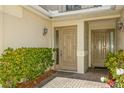 Front entry with double doors and neatly landscaped shrubs at 10426 La Mirage Ct, Tampa, FL 33615
