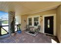 Inviting front porch with stone columns, tile flooring, and comfortable seating at 2628 River Bend Dr, Ruskin, FL 33570