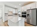 Bright kitchen featuring white cabinetry, stainless steel appliances, and a spacious center island at 9413 Ballaster Pointe Loop, Parrish, FL 34219