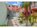 Exterior showing a walkway, stairs, garage, and lush landscaping at 6800 Sunset Way # 1708, St Pete Beach, FL 33706