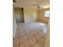 Spacious room with neutral walls and tiled flooring, illuminated by a ceiling fan and natural light from a window at 4407 N 41St St, Tampa, FL 33610