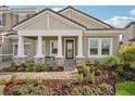 Inviting front entrance with a covered porch, stone accents, and a double door at 14292 Swiss Bridge Dr, Riverview, FL 33579