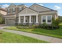 Two-story house with gray siding, a three-car garage, and a well-maintained lawn at 14292 Swiss Bridge Dr, Riverview, FL 33579