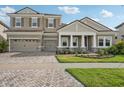 Two-story house with gray siding, three car garage and nicely landscaped yard at 14292 Swiss Bridge Dr, Riverview, FL 33579