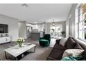 Open living room with modern furniture, hardwood floors and a view into the kitchen at 2220 Grenadier Dr # 2220, Sun City Center, FL 33573
