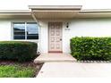 Condo entrance featuring a light beige door and well-maintained landscaping at 2220 Grenadier Dr # 2220, Sun City Center, FL 33573