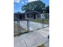 Ranch-style home with carport and chain-link fence at 10007 N 26Th St, Tampa, FL 33612