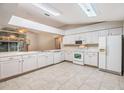 Galley-style kitchen with white cabinets and tile flooring at 6928 Stephens Path, Zephyrhills, FL 33542