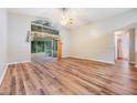Bright living room with laminate floors and sliding glass doors leading to a screened porch at 6928 Stephens Path, Zephyrhills, FL 33542