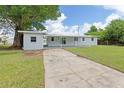 Single-story home featuring a driveway leading to the backyard with lush lawn at 801 Brodhag Dr, Punta Gorda, FL 33950