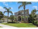 Two-story house with palm trees, landscaped lawn, and a paved walkway at 4904 W San Miguel St, Tampa, FL 33629