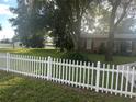 House exterior showcasing a white picket fence and lush green lawn at 10520 Henderson Rd, Tampa, FL 33625