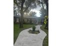 Curved walkway leads to charming house exterior, surrounded by trees at 10520 Henderson Rd, Tampa, FL 33625