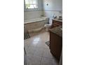 Bathroom with tile floors, built-in bathtub, and granite vanity at 2905 W Osborne Ave, Tampa, FL 33614
