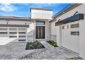 Modern home with a gray two-car garage and stone accents at 8320 Golden Beach Ct, Parrish, FL 34219