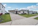 Beautiful single-story home with a modern design, three-car garage, and patterned brick driveway at 8320 Golden Beach Ct, Parrish, FL 34219