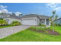 One story home with gray exterior, two car garage and landscaped yard at 18337 Vizcaya Ct, Venice, FL 34293