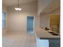 Bright kitchen featuring white tile floors, a long counter, and views of a laundry room at 5125 Palm Springs Blvd # 1303, Tampa, FL 33647