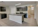 Modern kitchen with dark cabinets, granite countertops, and island at 9538 Highland Ridge Dr, Hudson, FL 34667