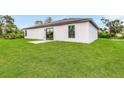 Landscaped backyard with grassy area and patio at 3769 S Haberland Blvd, North Port, FL 34288