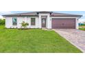 Modern house exterior with a paved driveway and landscaping at 5473 Colfax Ter, Port Charlotte, FL 33981