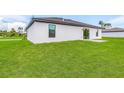 Rear view of modern house with grassy backyard at 5473 Colfax Ter, Port Charlotte, FL 33981