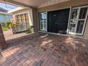Inviting covered front porch with a swing, brick columns, and double front doors at 3931 E Eden Roc Cir, Tampa, FL 33634