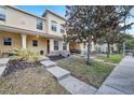 Tan townhome with stone accents, a front porch and a magnolia tree at 10957 Keys Gate Dr, Riverview, FL 33579