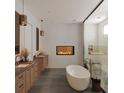 Modern bathroom featuring a fireplace, freestanding tub, and dual vanities at 4305 W Zelar St, Tampa, FL 33629