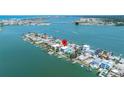 Aerial shot of waterfront homes with docks offering beautiful views of the water and skyline at 831 Bay Point Dr, Madeira Beach, FL 33708
