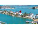 Stunning aerial view of waterfront homes along the bay with private boat docks and city views at 831 Bay Point Dr, Madeira Beach, FL 33708