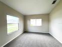 Cozy bedroom with large windows, carpet flooring, and neutral walls at 12009 Pennfield Pl, Riverview, FL 33579