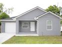 Gray single Gathering home featuring white trim, a driveway, and a manicured lawn at 710 E Alabama St, Plant City, FL 33563