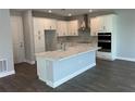 Modern kitchen featuring white cabinets, island with waterfall countertop, and stainless steel appliances at 4017 W Fig St, Tampa, FL 33609