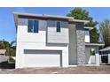Modern two-story home featuring a gray and white exterior, stone accents and an attached two-car garage at 707 W Fribley St, Tampa, FL 33603