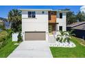 Modern two-story home with a two-car garage, highlighted by fresh landscaping and a vibrant green lawn at 7615 S Swoope St, Tampa, FL 33616