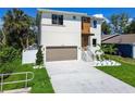 A modern two-story home featuring a two-car garage, landscaped front yard, and a bright, well-maintained lawn at 7615 S Swoope St, Tampa, FL 33616