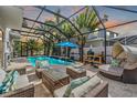 Inviting pool area with covered patio, lounge furniture, and a waterfall feature at 11116 Hoffner Edge Dr, Riverview, FL 33579